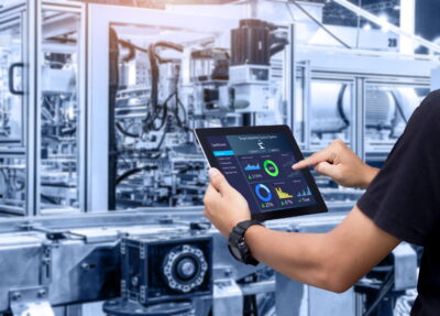 Smart industry control concept.Hands holding tablet on blurred automation machine as background Ⓒpanuwat @Adobe Stock