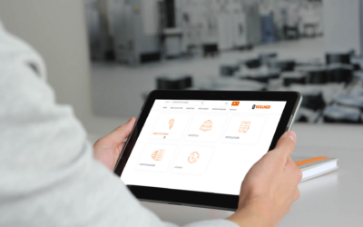 VOLLMER_Kundenportal_Tablet Mitarbeiter steht vor der Maschine mit einem Ipad (© VOLLMER WERKE)